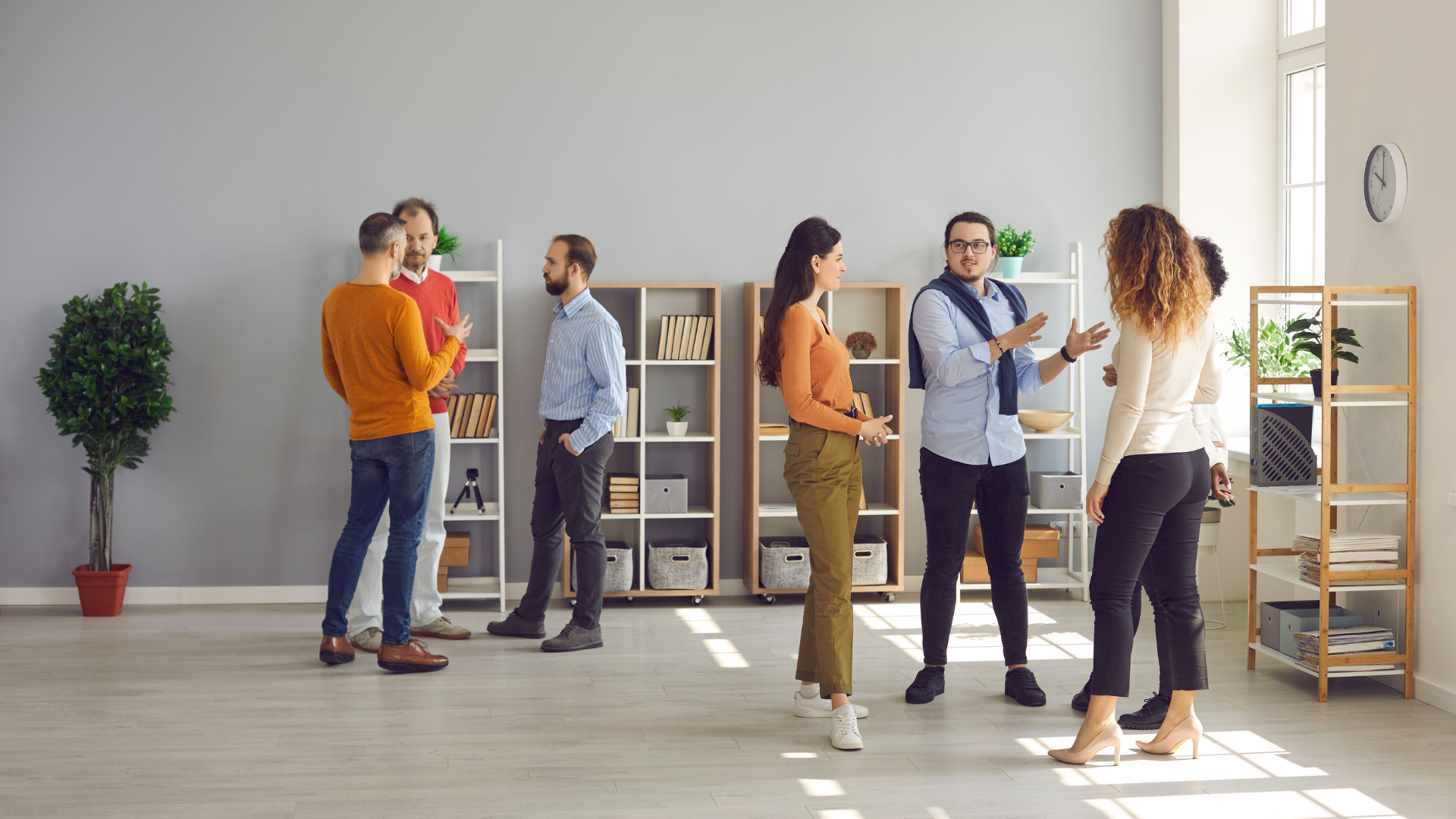 how to improve interpersonal skills people standing and chatting in a room with bookshelves